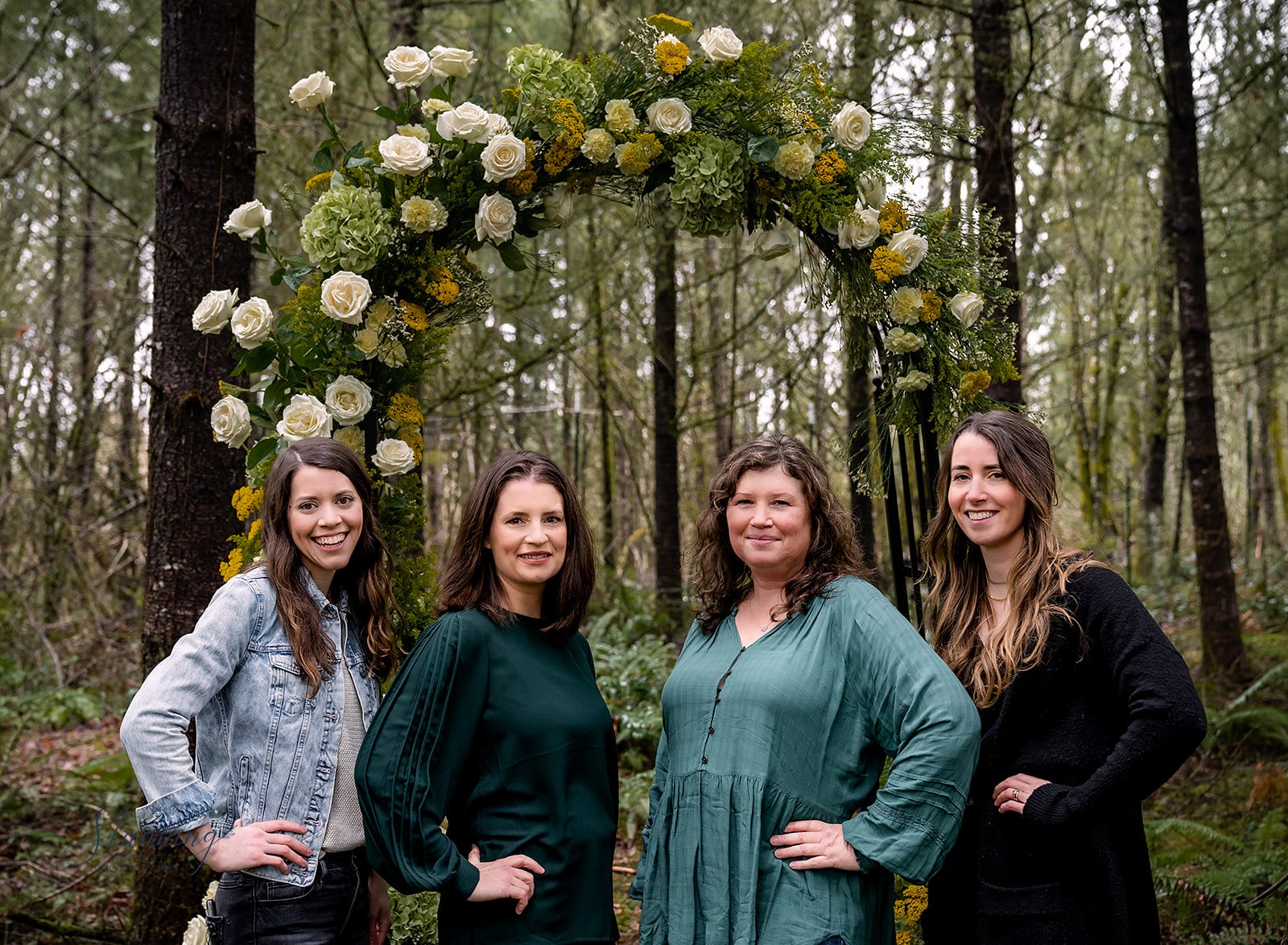 team photo in front of floral arbor