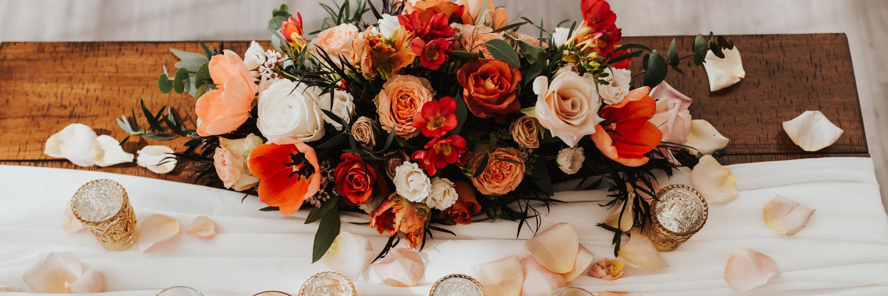 wedding sweetheart table with flower arrangement and petals