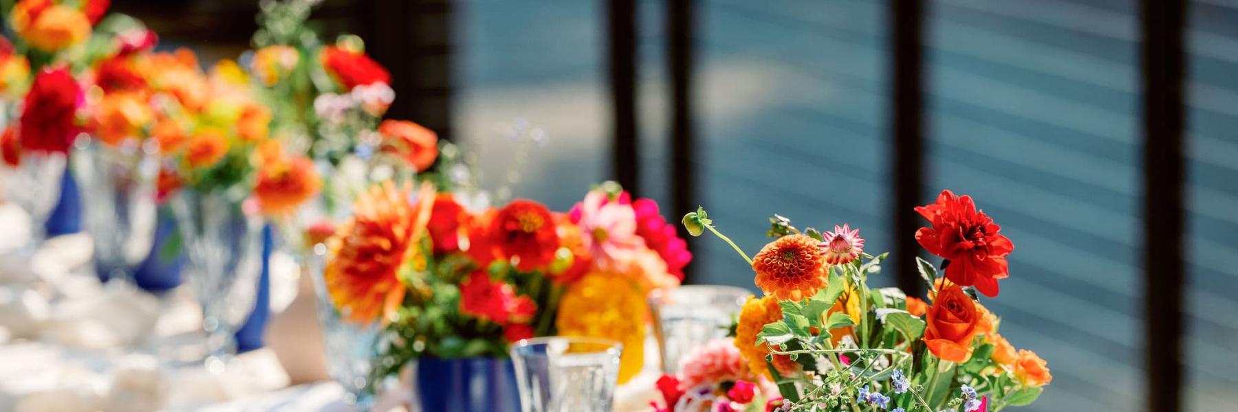 long table of colorful floral bud vases