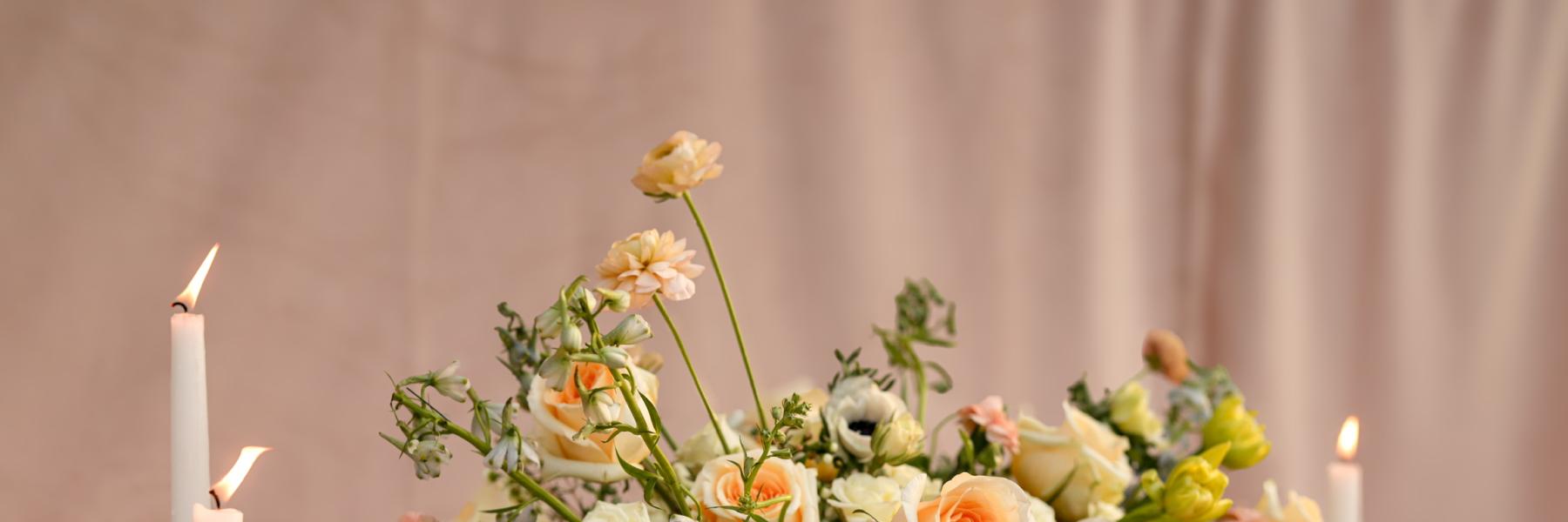 long floral centerpiece in garden party style with tapered candles and tea lights 