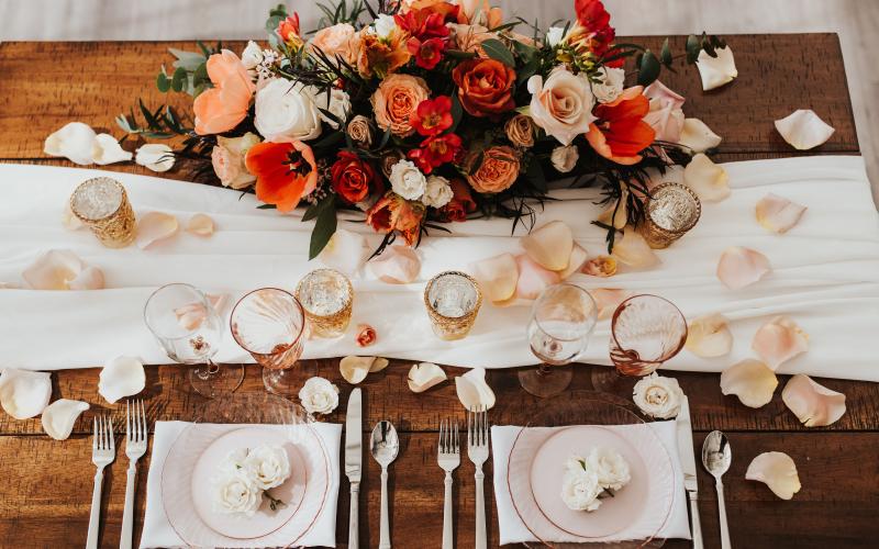 wedding sweetheart table with flower arrangement and petals