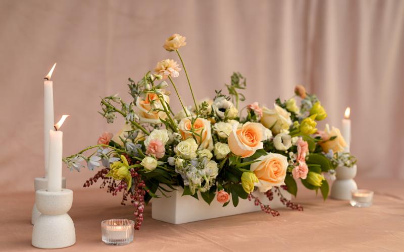 long floral centerpiece in garden party style with tapered candles and tea lights 