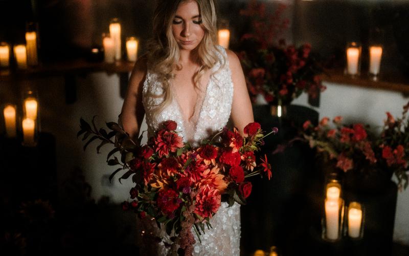 bride holding bouquet of all red flowers