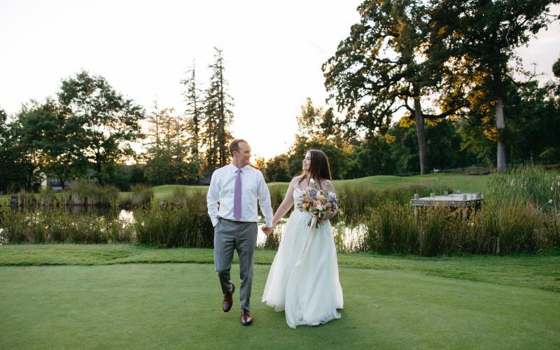 bride and groom walking the green