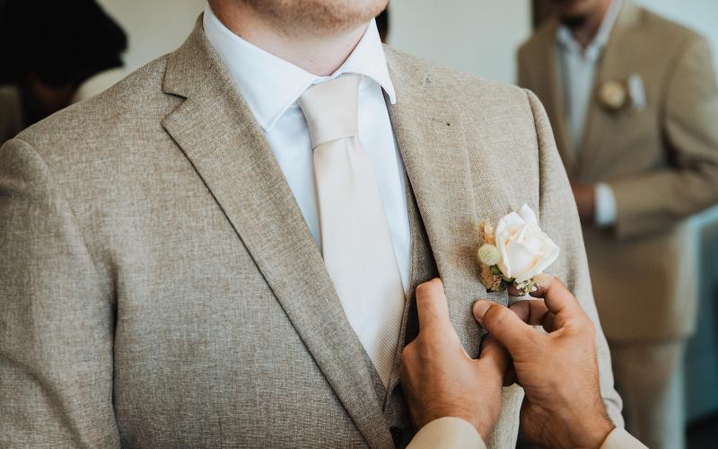 pinning a boutonniere on a jacket
