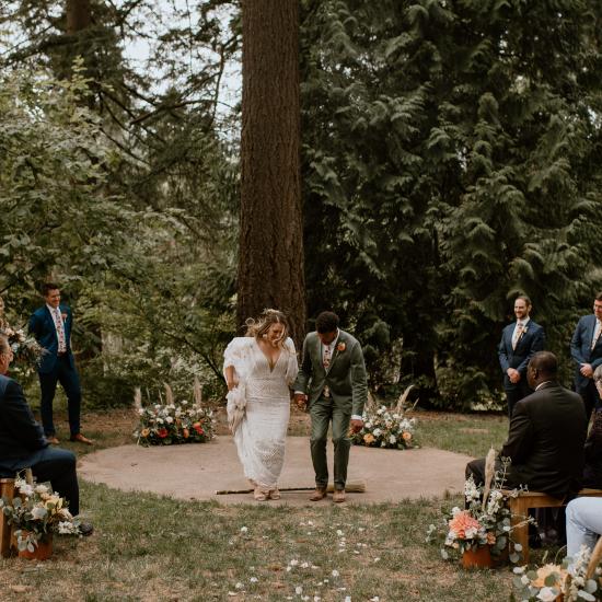 Backdrop of 2 large, upgrowing arrangements, aisle lined with custom arrangements