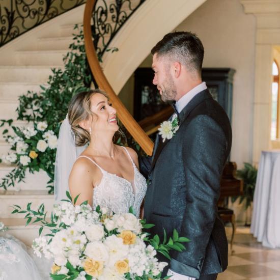 bride and groom in front of staircase