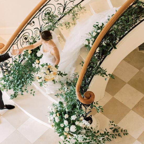 Groom leading bride down stairs