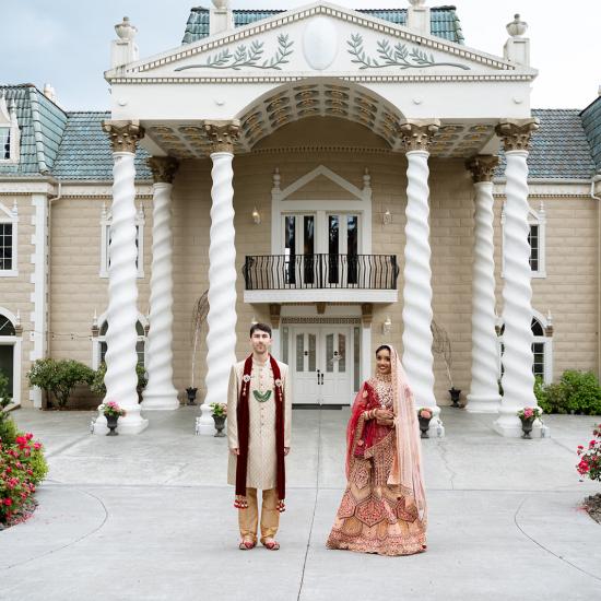 bride and groom in front of estate