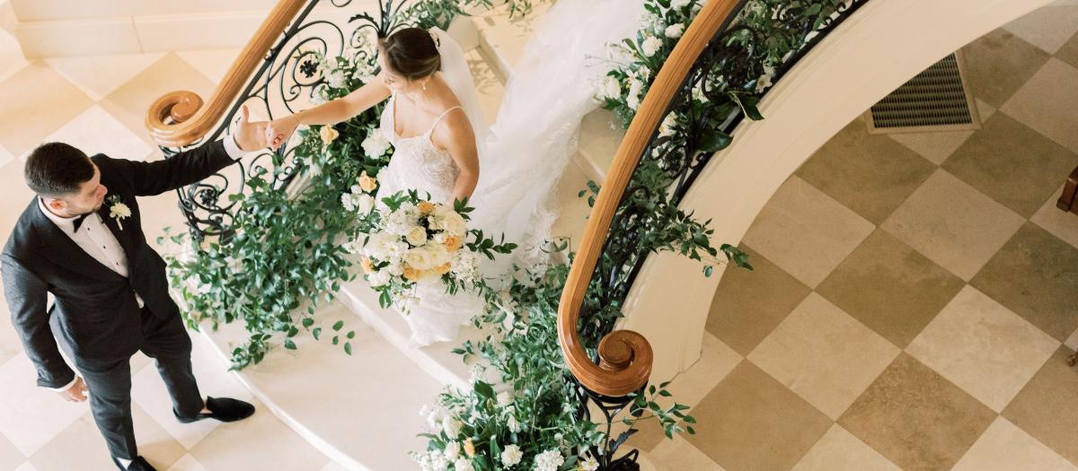 Groom leading bride down stairs