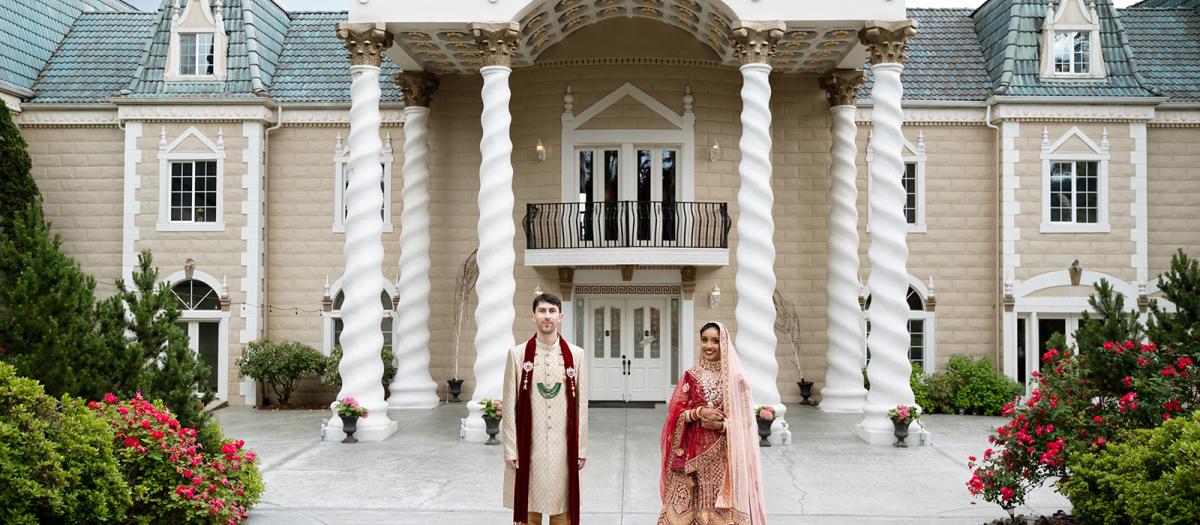 bride and groom in front of estate